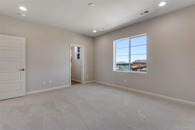 spare room featuring light colored carpet