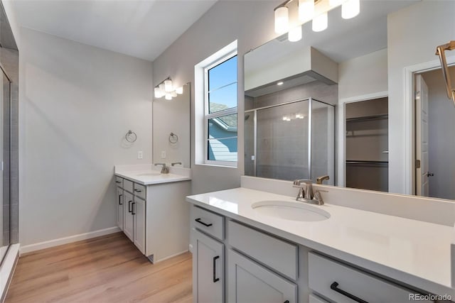 bathroom with vanity, hardwood / wood-style floors, and a shower with door