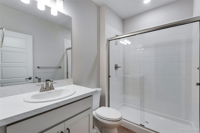 bathroom with vanity, an enclosed shower, and toilet