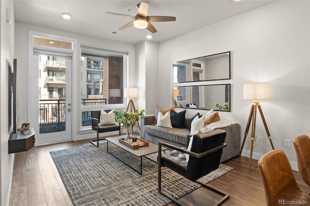 living area featuring visible vents, baseboards, a ceiling fan, and hardwood / wood-style floors