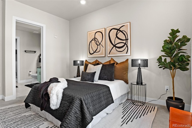 carpeted bedroom featuring baseboards and ensuite bath