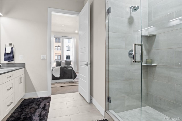 ensuite bathroom with vanity, baseboards, a stall shower, tile patterned floors, and connected bathroom