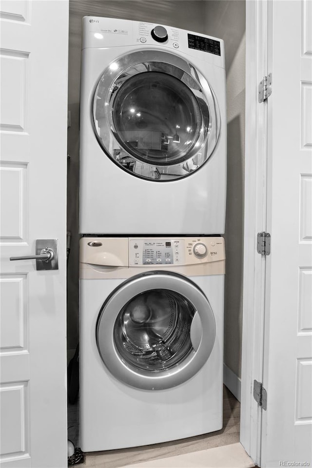 clothes washing area with laundry area and stacked washer and dryer