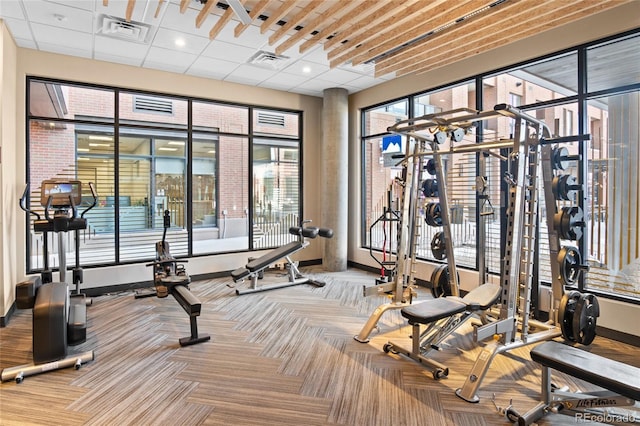 gym with a wealth of natural light, visible vents, and carpet flooring