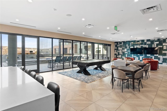 recreation room featuring an accent wall, visible vents, and wallpapered walls