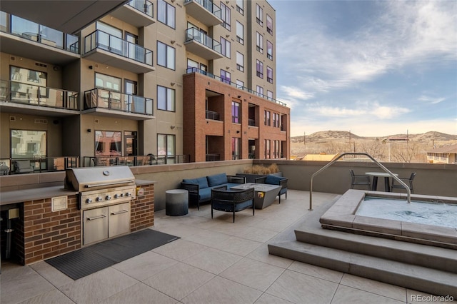 view of patio / terrace with an outdoor living space with a fire pit, exterior kitchen, area for grilling, and a mountain view