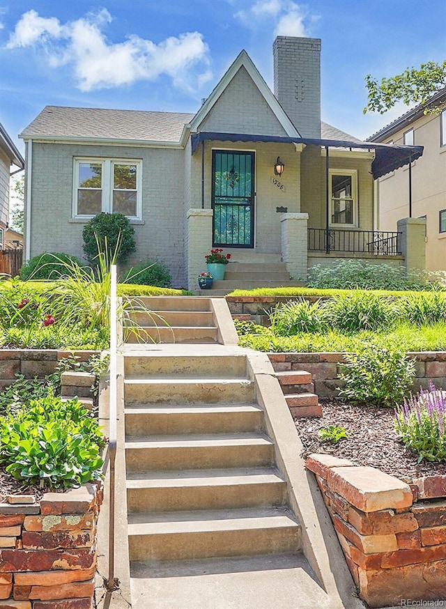 1208 S Elizabeth St, Denver, CO 80210 - view of front of property with stairway, a chimney, brick siding, and covered porch
