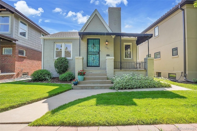 1208 S Elizabeth St, Denver, CO 80210 - view of front of home with a chimney, a front lawn, covered porch, and brick siding