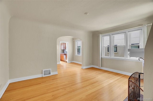 1208 S Elizabeth St, Denver, CO 80210 - spare room with arched walkways, wood finished floors, and baseboards