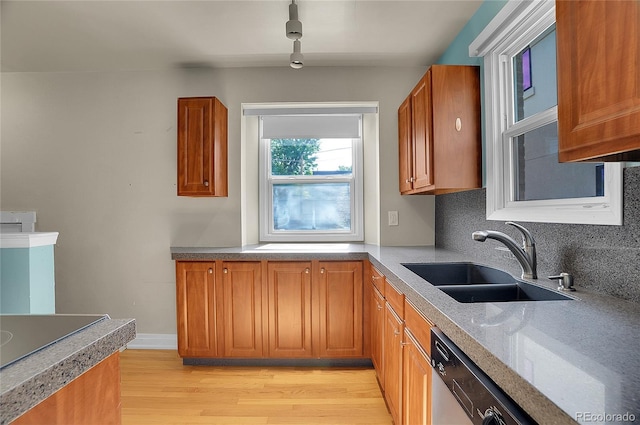 1208 S Elizabeth St, Denver, CO 80210 - kitchen featuring a sink, stainless steel dishwasher, brown cabinets, light wood finished floors, and tasteful backsplash