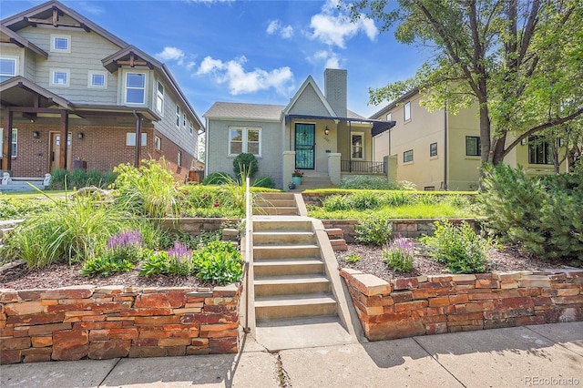 1208 S Elizabeth St, Denver, CO 80210 - view of front of home featuring covered porch, a chimney, and stucco siding