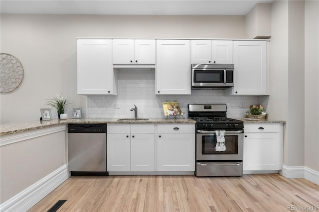 328 E Dakota Ave, Denver, CO 80209 - kitchen featuring appliances with stainless steel finishes, a sink, light wood finished floors, and baseboards