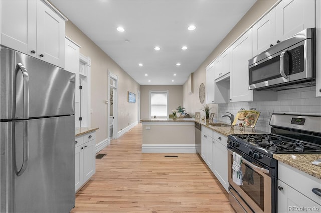 328 E Dakota Ave, Denver, CO 80209 - kitchen featuring appliances with stainless steel finishes, recessed lighting, light wood-style flooring, decorative backsplash, and white cabinetry