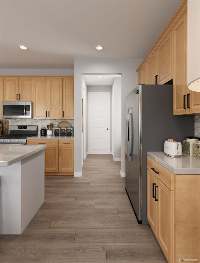 kitchen featuring recessed lighting, light countertops, light brown cabinetry, and appliances with stainless steel finishes