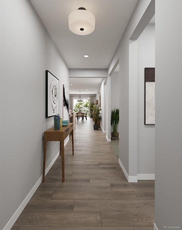 corridor with baseboards, recessed lighting, and wood finished floors