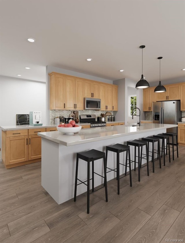 kitchen with backsplash, stainless steel appliances, light wood-style flooring, and a sink