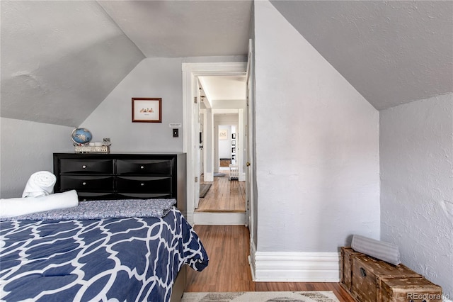 2358 N Ogden St Unit B, Denver, CO 80205 - bedroom featuring lofted ceiling, wood finished floors, and a textured wall