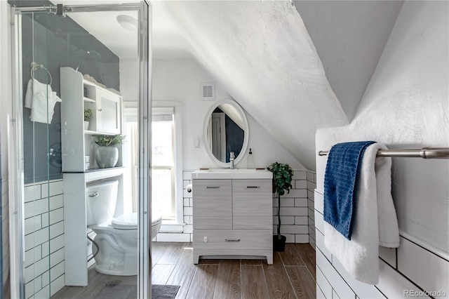 2358 N Ogden St Unit B, Denver, CO 80205 - full bathroom featuring lofted ceiling, vanity, wood finished floors, a shower with door, and tile walls