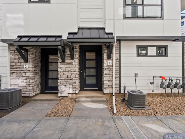 2050 S Holly St Unit 1, Denver, CO 80222 - doorway to property with a standing seam roof, stone siding, and a metal roof
