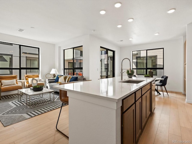 2050 S Holly St Unit 1, Denver, CO 80222 - kitchen with light wood-type flooring, open floor plan, light countertops, and recessed lighting