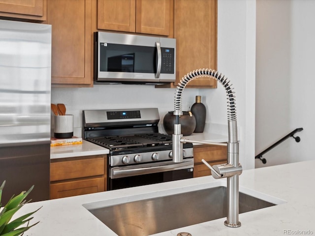 2050 S Holly St Unit 1, Denver, CO 80222 - kitchen with appliances with stainless steel finishes and brown cabinetry
