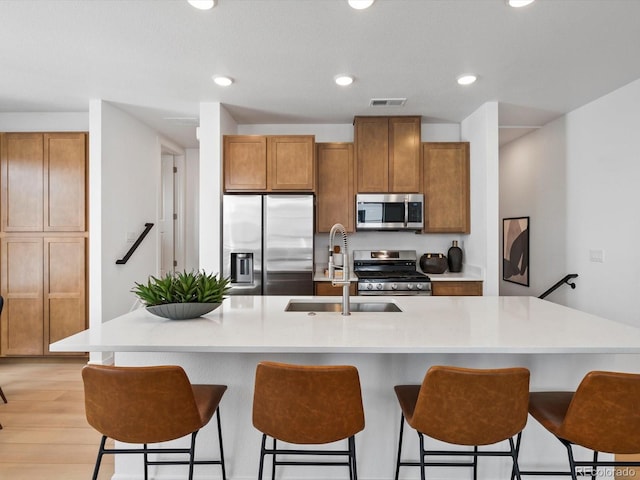 2050 S Holly St Unit 1, Denver, CO 80222 - kitchen with stainless steel appliances, brown cabinetry, light countertops, and recessed lighting