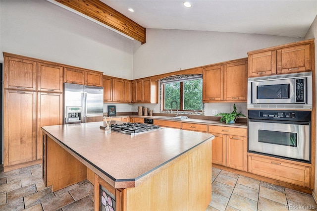 kitchen featuring high vaulted ceiling, built in appliances, a kitchen bar, a center island, and sink