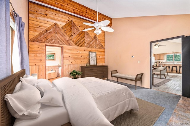 bedroom with high vaulted ceiling, hardwood / wood-style flooring, wooden walls, and ceiling fan