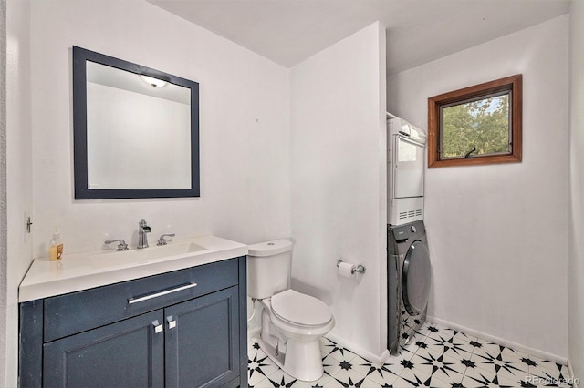 bathroom featuring vanity, toilet, and stacked washing maching and dryer