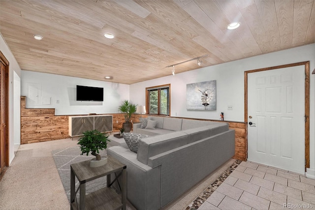 living room with track lighting, wood walls, and wooden ceiling