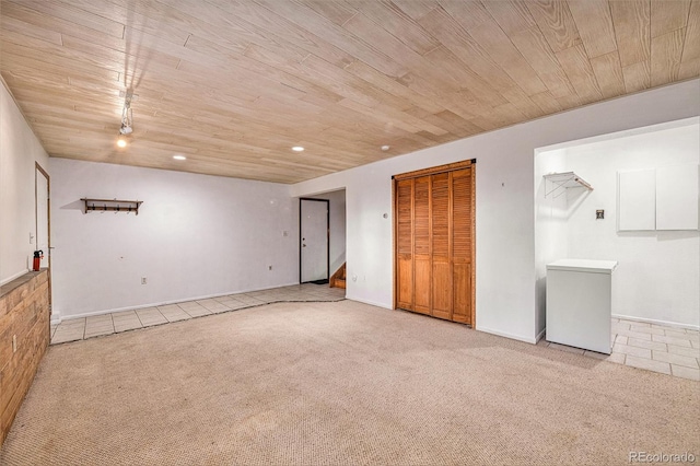 unfurnished room featuring wood ceiling and light colored carpet