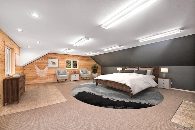 bedroom with a textured ceiling, vaulted ceiling, wood walls, and light carpet