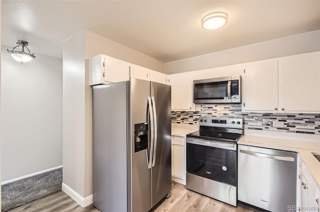 kitchen with tasteful backsplash, light wood finished floors, light countertops, appliances with stainless steel finishes, and white cabinets