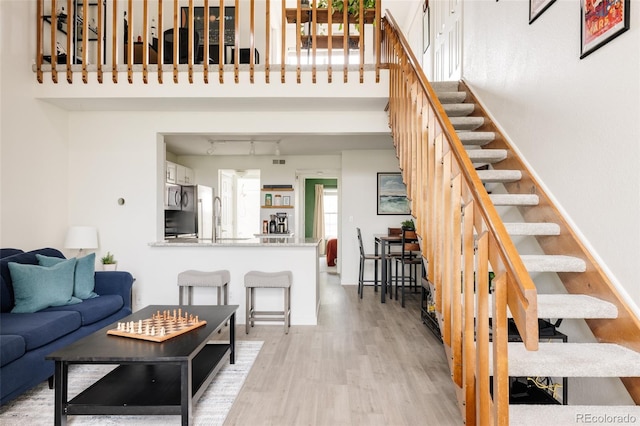 3026 W Prentice Ave Unit H, Littleton, CO 80123 - living room with wood finished floors, stairs, and a high ceiling
