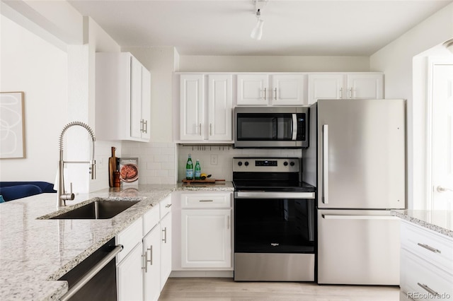 3026 W Prentice Ave Unit H, Littleton, CO 80123 - kitchen with stainless steel appliances, white cabinets, light wood finished floors, and light stone countertops