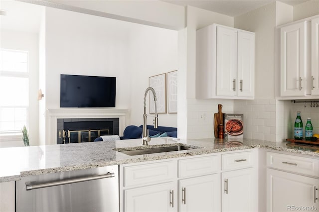 3026 W Prentice Ave Unit H, Littleton, CO 80123 - kitchen featuring stainless steel dishwasher, open floor plan, tasteful backsplash, and light stone counters