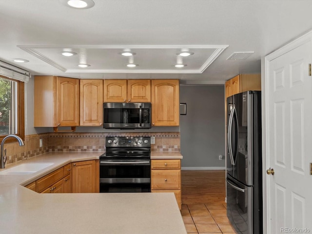 5903 S Ward St, Littleton, CO 80127 - kitchen with stainless steel microwave, black range with electric cooktop, freestanding refrigerator, light tile patterned flooring, and light countertops