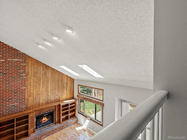 5903 S Ward St, Littleton, CO 80127 - hall featuring a textured ceiling, lofted ceiling, wood finished floors, a skylight, and wood walls