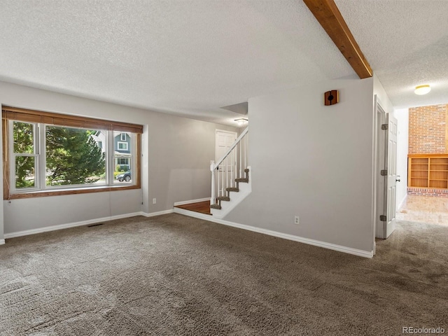 5903 S Ward St, Littleton, CO 80127 - unfurnished living room with a textured ceiling, carpet floors, stairs, and beam ceiling
