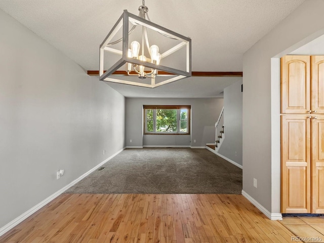 5903 S Ward St, Littleton, CO 80127 - unfurnished room with hardwood / wood-style flooring, stairway, and a chandelier