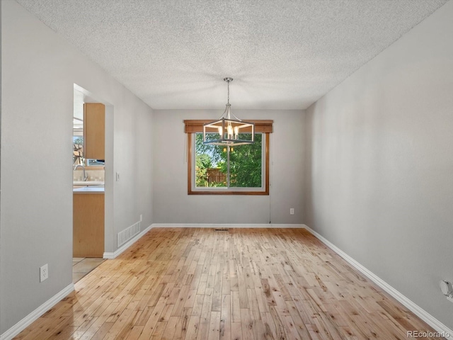 5903 S Ward St, Littleton, CO 80127 - empty room with hardwood / wood-style flooring, a chandelier, and a textured ceiling