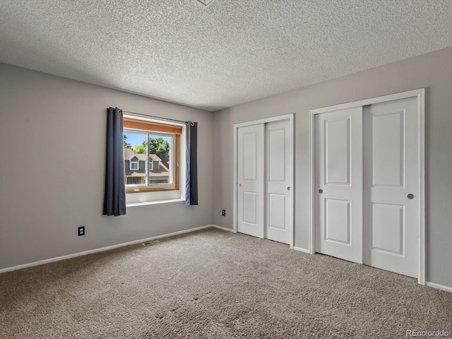 5903 S Ward St, Littleton, CO 80127 - unfurnished bedroom with multiple closets, carpet floors, and a textured ceiling