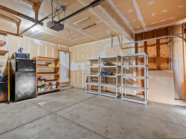5903 S Ward St, Littleton, CO 80127 - garage featuring a garage door opener and freestanding refrigerator