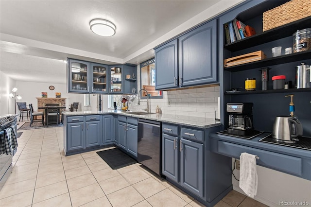 kitchen with stainless steel appliances, light stone countertops, sink, and blue cabinetry