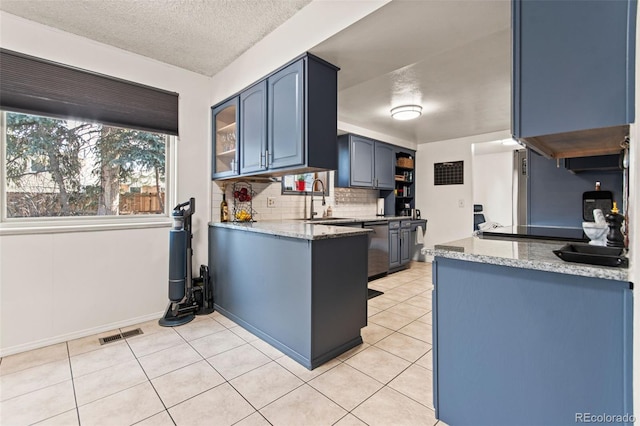 kitchen featuring light tile patterned flooring, blue cabinets, sink, dishwasher, and decorative backsplash