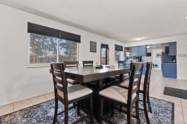 tiled dining area with a textured ceiling