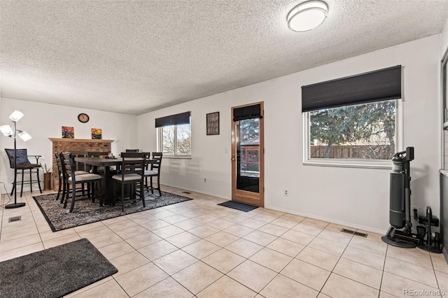 dining space with light tile patterned flooring and a textured ceiling