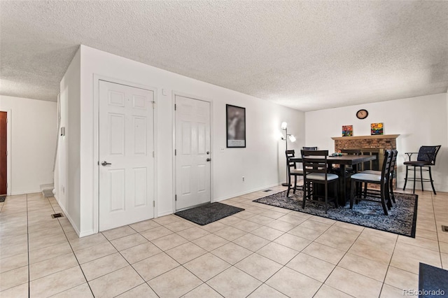 dining space with light tile patterned floors and a textured ceiling