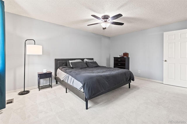 carpeted bedroom with ceiling fan and a textured ceiling