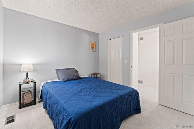 bedroom with light carpet and a textured ceiling